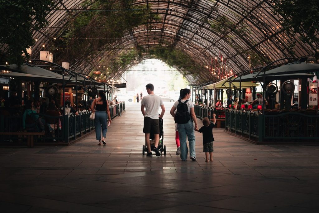 Família passeando em mercado coberto com cordões de luz no estilo Natal Luz Gramado