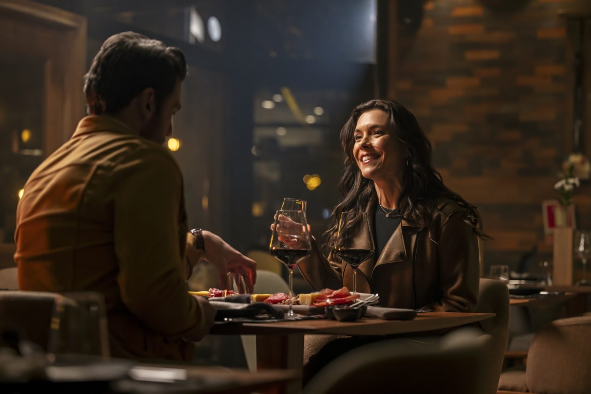 Casal em jantar romântico em restaurante sofisticado com vinho e tábua de frios serranos